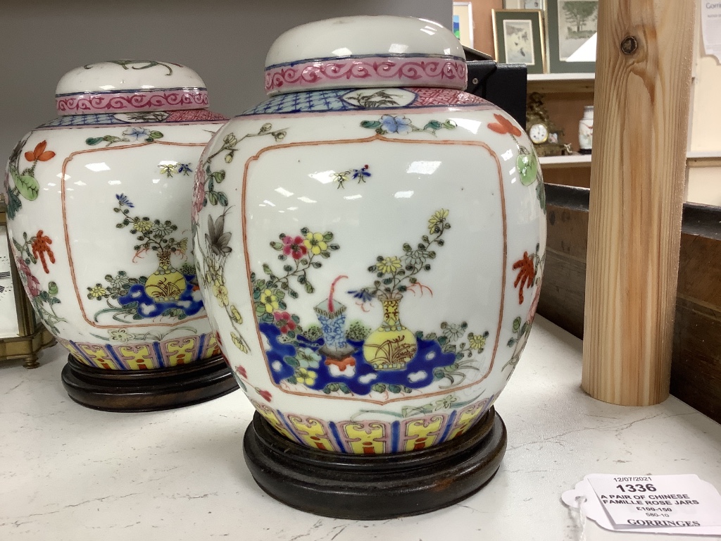 A pair of Chinese famille rose jars and covers, late 19/early 20th century, 15.5cm, on hardwood stands